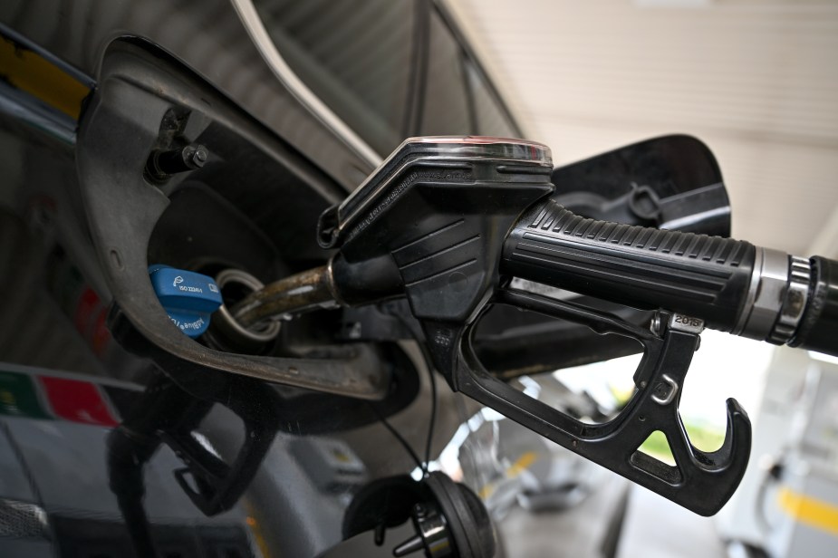 A black gas nozzle pumping gas as gas prices continue going up.