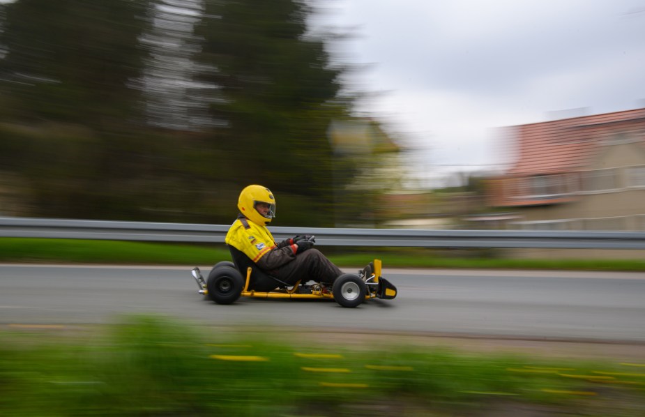 A go kart driving down the road. 