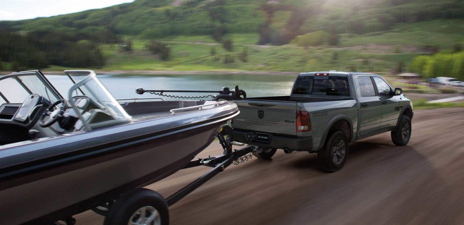 Gray 2022 Ram 1500 Classic, the only full-size pickup truck that costs less than $30,000, towing a boat