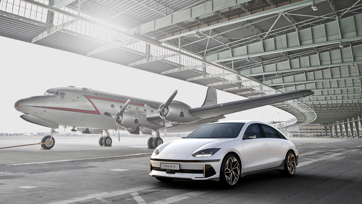 Hyundai Ioniq 6 EV parked in front of airplane in a hanger for design reveal photo