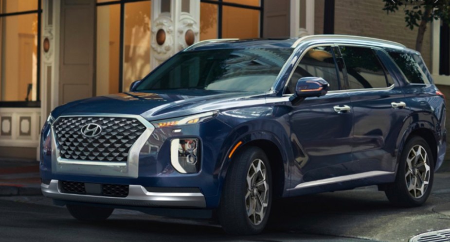 A blue 2022 Hyundai Palisade midsize SUV is on the road. 