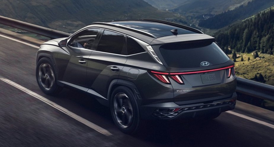 A gray 2022 Hyundai Tucson Plug-in Hybrid SUV is driving on the road.