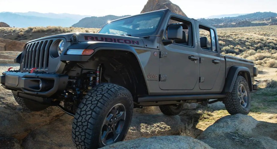 A gray 2022 Jeep Gladiator is driving over rocks. 