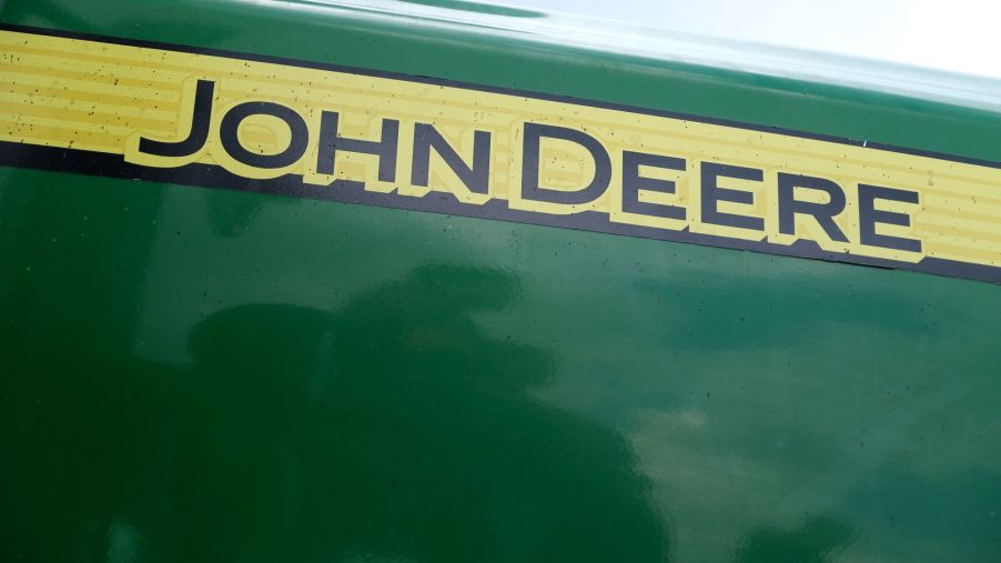 john Deere written on the traditional green John Deere lawn mower on a yellow strip in black.