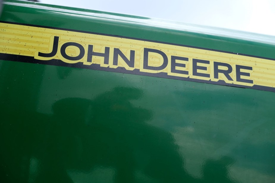 John Deere written on the traditional green John Deere lawn mower on a yellow strip in black. 