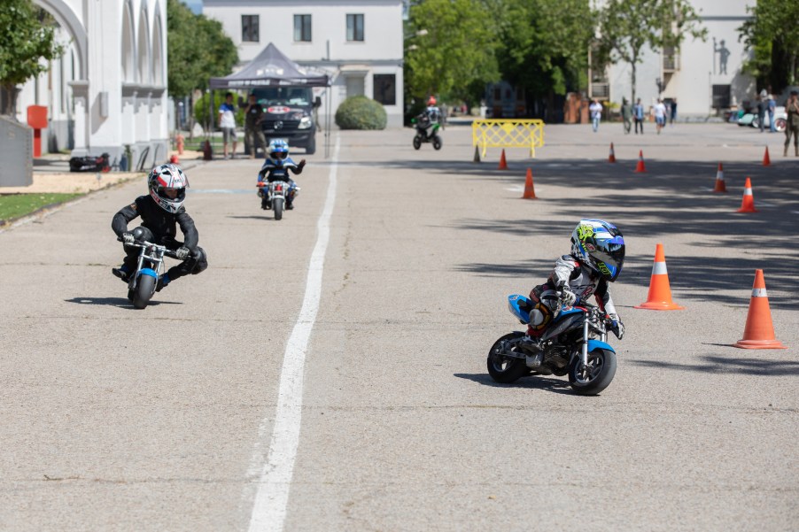 Children on kids motorcycles riding.