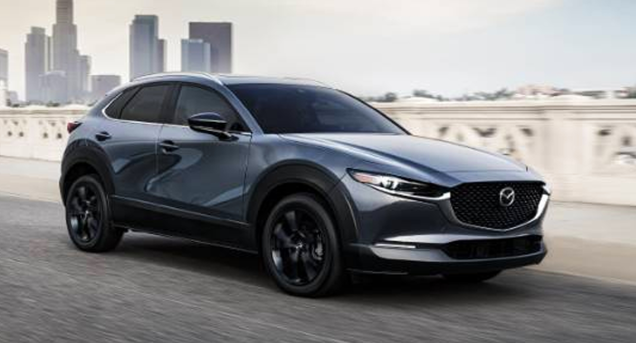 A gray 2022 Mazda CX-30 subcompact SUV is driving on the road.