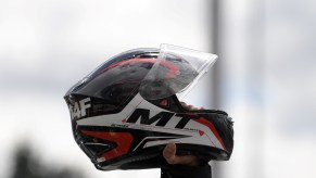 A motorcycle helmet being held in the air.