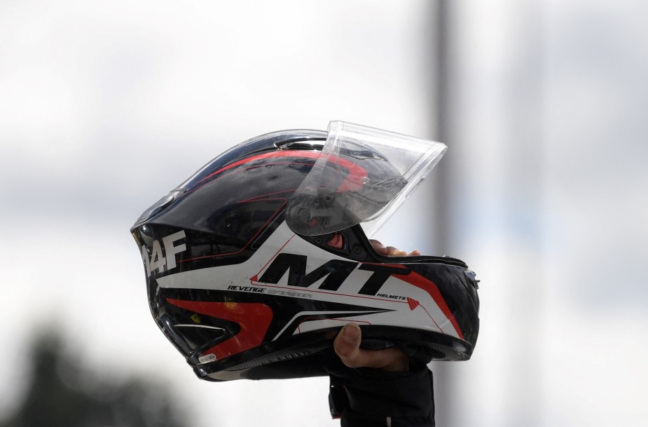 A motorcycle helmet being held in the air. 