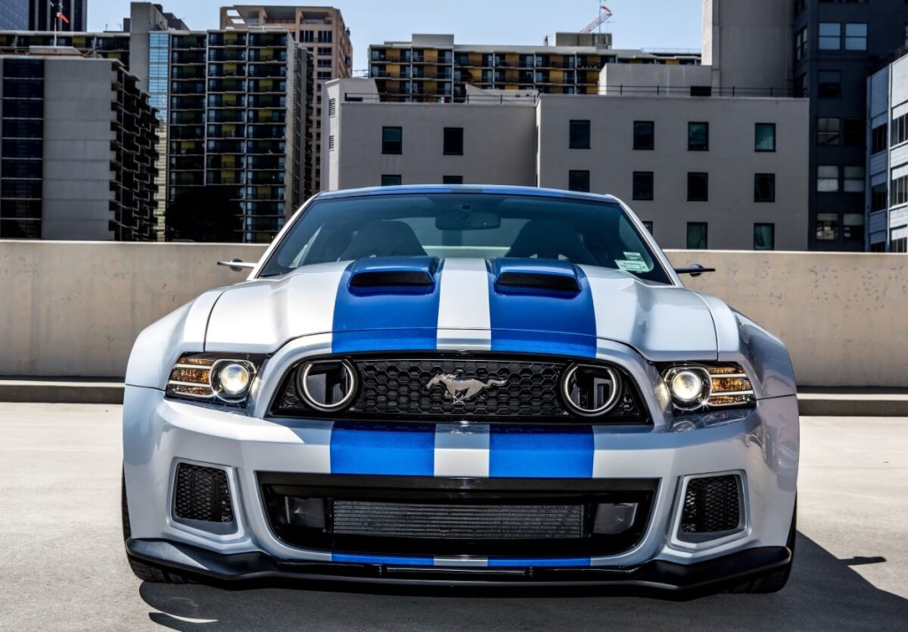 A silver and blue Ford Mustang Shelby GT500 from Need for Speed shows off its S197 front-end styling. 