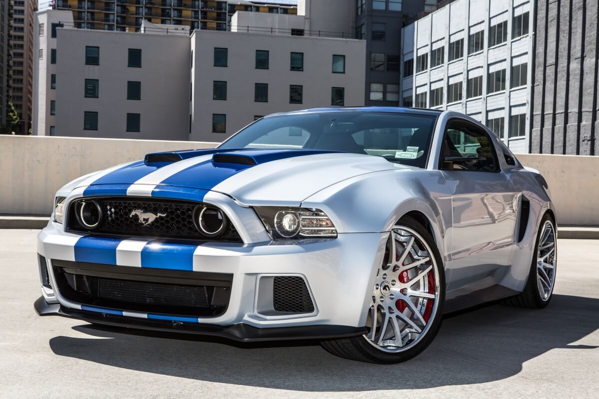 A silver and blue Ford Mustang Shelby GT500 from Need for Speed shows off its wheels.
