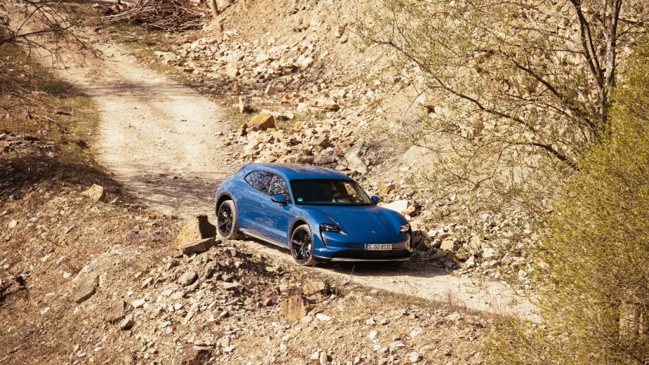 a neptune blue 2022 porsche taycan cross turismo, a new luxury electric car that uses its performance to take on more terrain