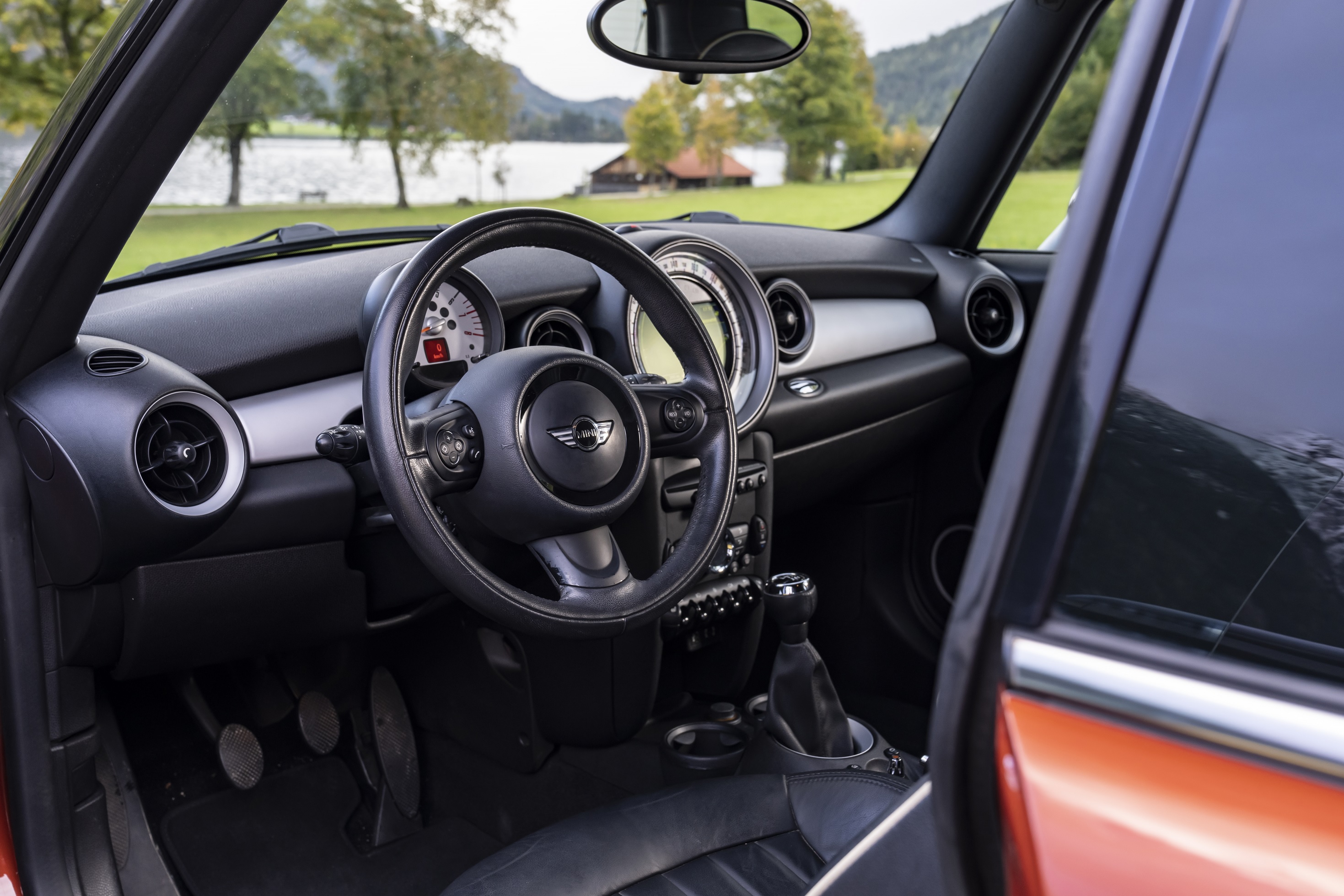The black-and-silver dashboard of an orange post-update R56 Mini Cooper