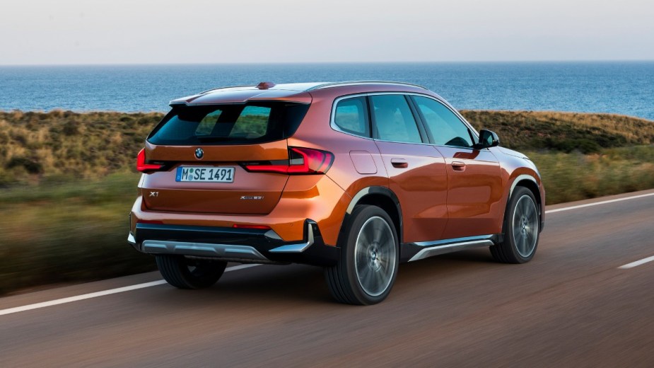 Rear angle view of orange 2023 BMW X1, highlighting its release date and price