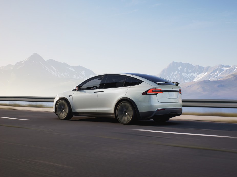 Rear angle view of white 2023 Tesla Model X, highlighting its release date and price