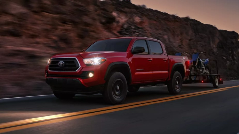 Red 2023 Toyota Tacoma, the best low-depreciation pickup truck, towing motorcycles