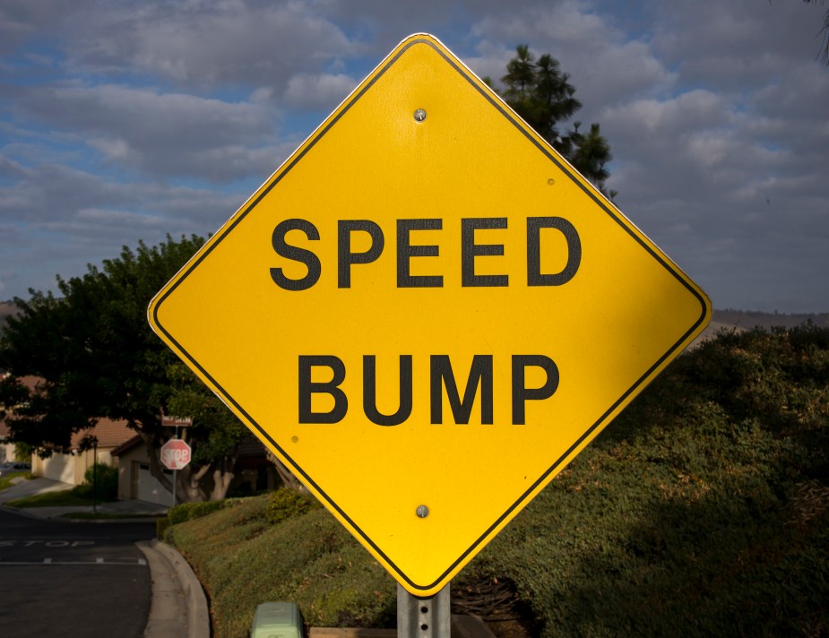 A yellow speed bump sign. 