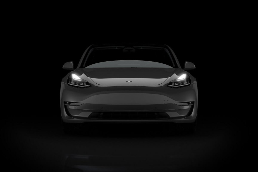 A dual-motor AWD Tesla Model 3 Performance shows off its front-end styling in the dark. 