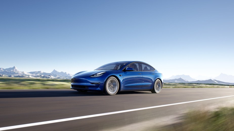 a blue tesla model 3, a family electric car with the range you need