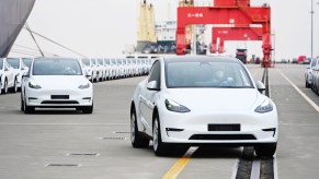 A long line of 2022 Tesla Model Y cars outdoors.