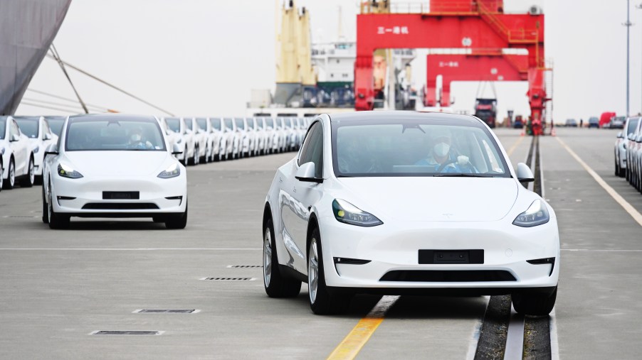 A long line of 2022 Tesla Model Y cars outdoors.