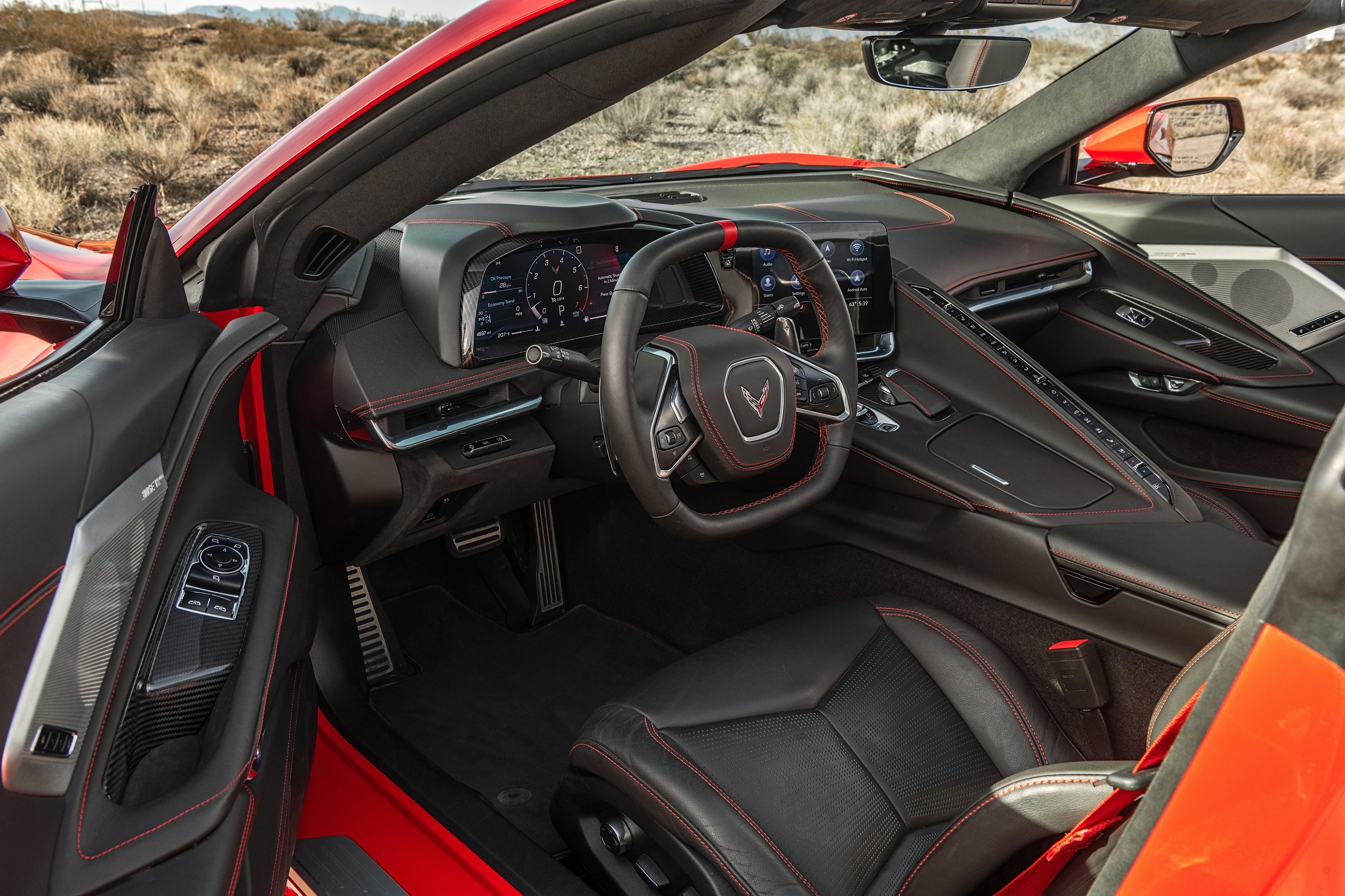 The black seats and convertible of a red 2022 Chevrolet C8 Corvette Stingray Convertible in the desert