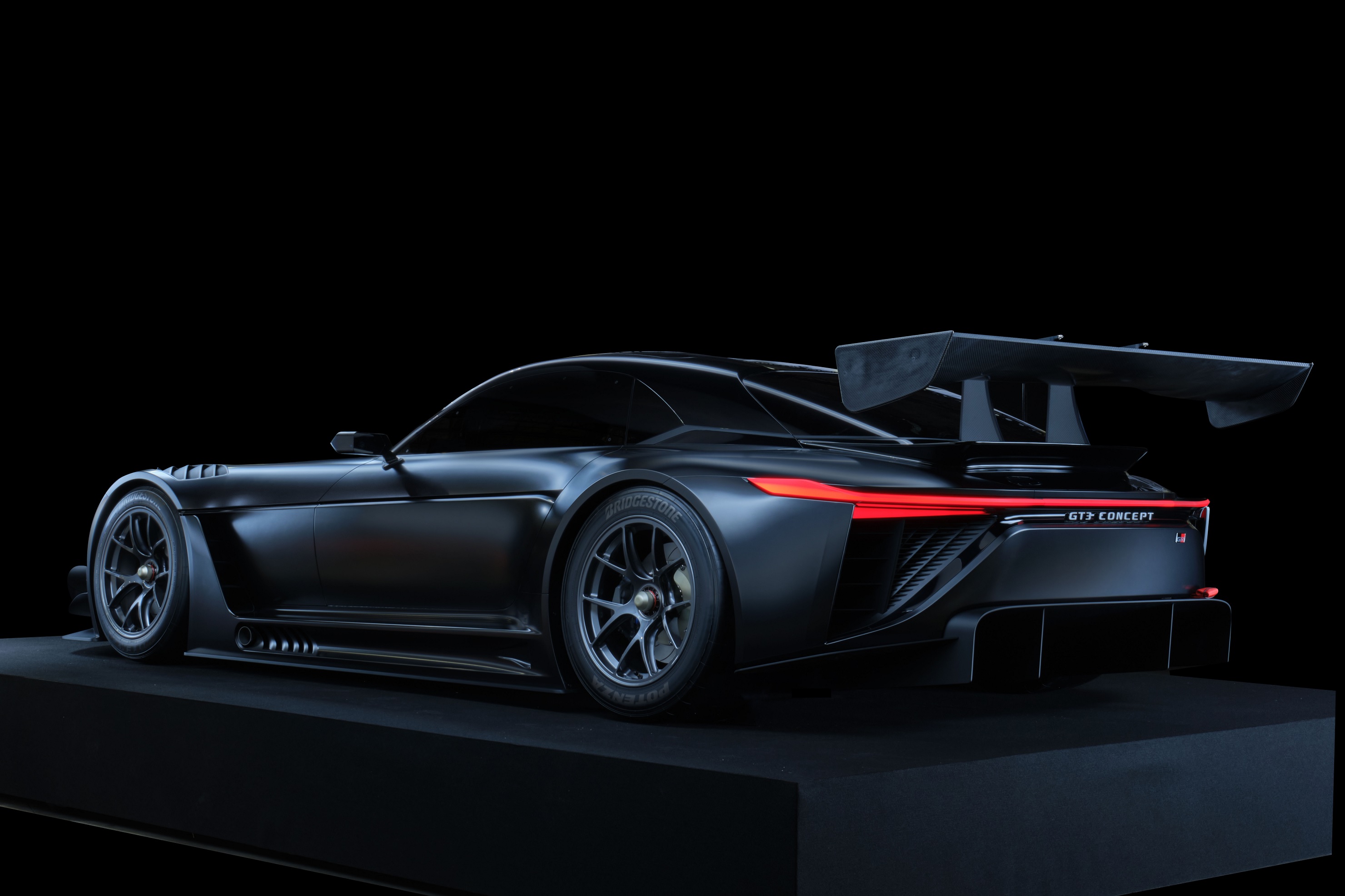 The rear view of the black 2022 Toyota GR GT3 Concept on a stand