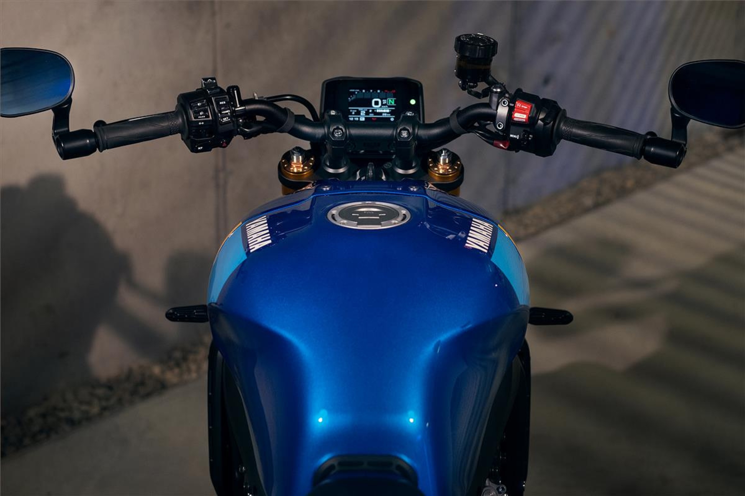 The full-color TFT dash and black handlebars with bar-end mirrors of a blue 2022 Yamaha XSR900