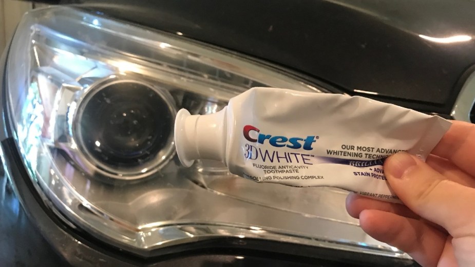 Toothpaste in front of a headlight, highlighting secret car cleaning tips 