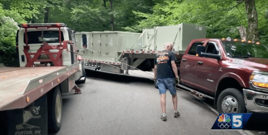 A tow truck driver attempts to pull a Ram Cummins pickup truck with a heavy trailer back onto the road of the Smuggler's Notch mountain pass.