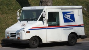 A USPS mail truck sits in a local neighborhood.