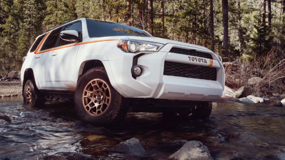 White 2023 Toyota 4Runner 40th Anniversary Edition playing in a creek