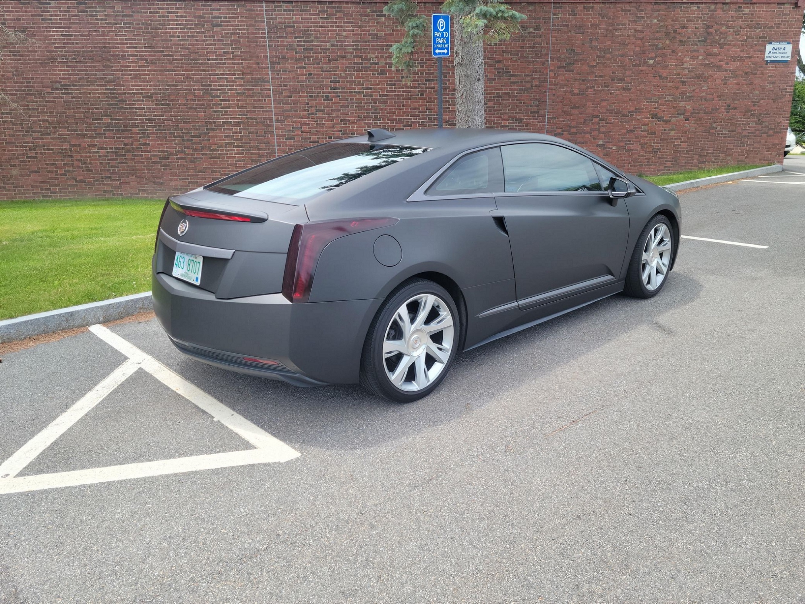 The rear 3/4 view of a black-wrapped 2014 Cadillac ELR in a parking lot