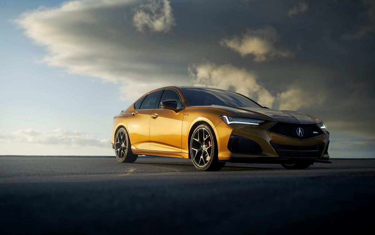 Passenger side view of a metallic yellow Acura TLX Type S driving.