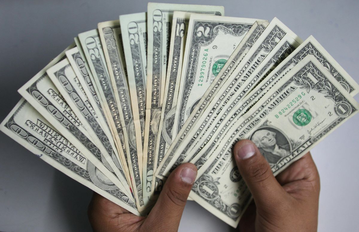 Hands holding fanned-out cash. Buying a car can be easier if you sell your current car for more.