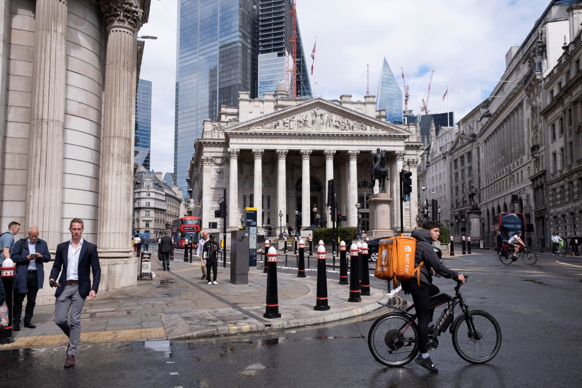 A bike courier rides through a square in London, a car-free city