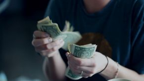 Close-up of a person counting out dollar bills