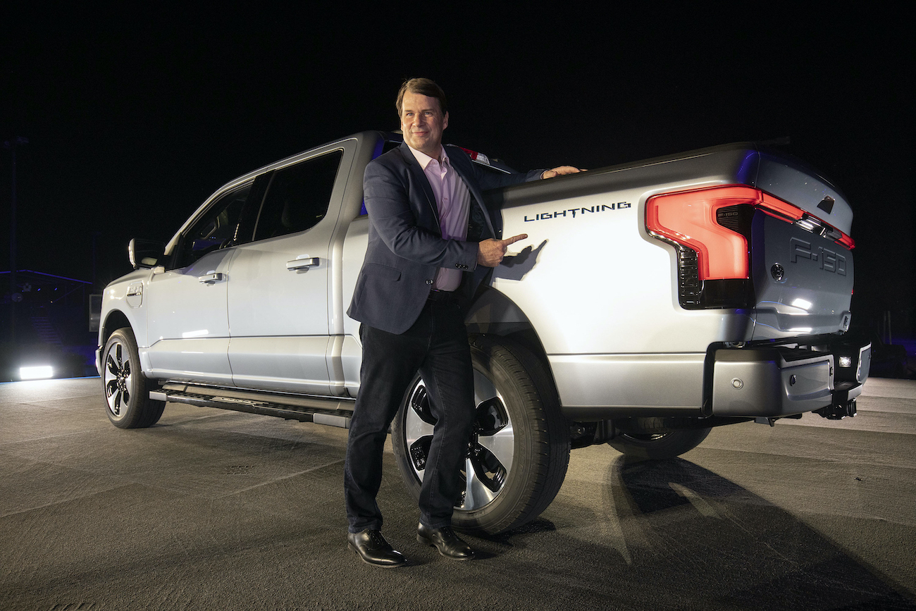 Ford's CEO, Jim Farley stands next to a Ford F-150 Lightning.