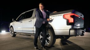 Ford's CEO, Jim Farley stands next to a Ford F-150 Lightning.