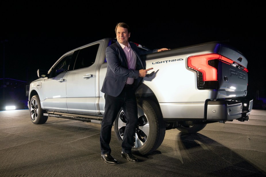 Ford's CEO, Jim Farley stands next to a Ford F-150 Lightning. 