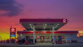The sunrising over a gas station and convenience store on a deserted highway.
