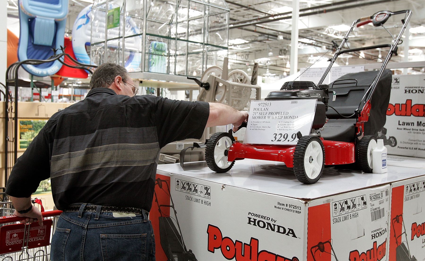 A man shopping for a lawn mower model at a Costco in Mount Prospect, Illinois