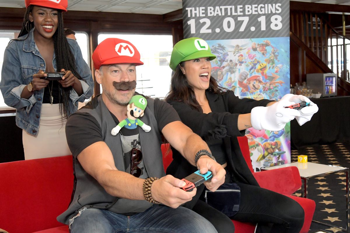 A trio of Mario Kart enthusiasts play in Mario and Luigi costumes at Comic Con 2018.