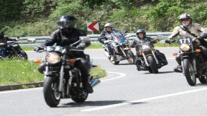 Motorcycle riders driving down the road.