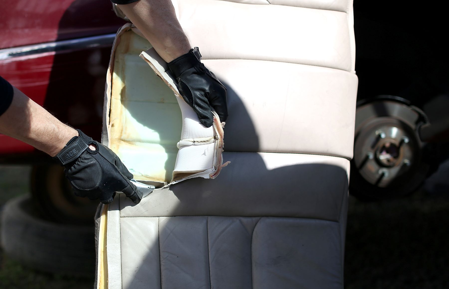 Removing old car seat leather upholstery during a reupholster process on a salvaged luxury car