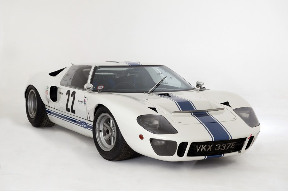 A white-with-a-blue-stripe 1967 Ford GT40 Mk1 in a white studio