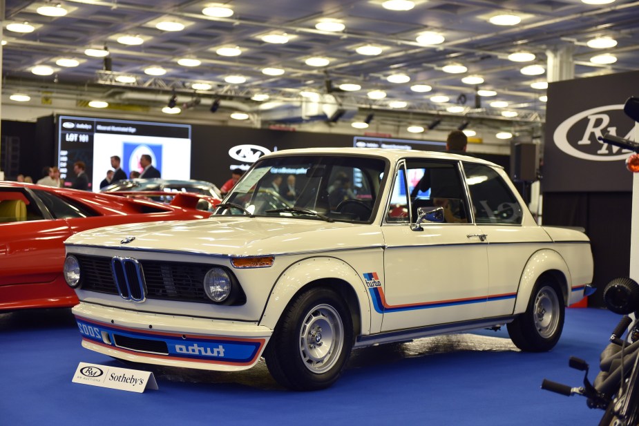 A white-with-red-and-blue-stripes 1974 BMW 2002 Turbo at an RM Sotheby's auction