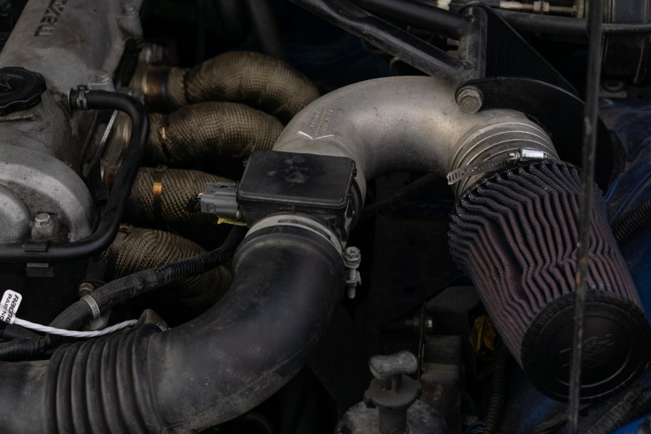 A 1999 Mazda MX-5 Miata's dirty aftermarket K&N high-performance air filter in the engine bay