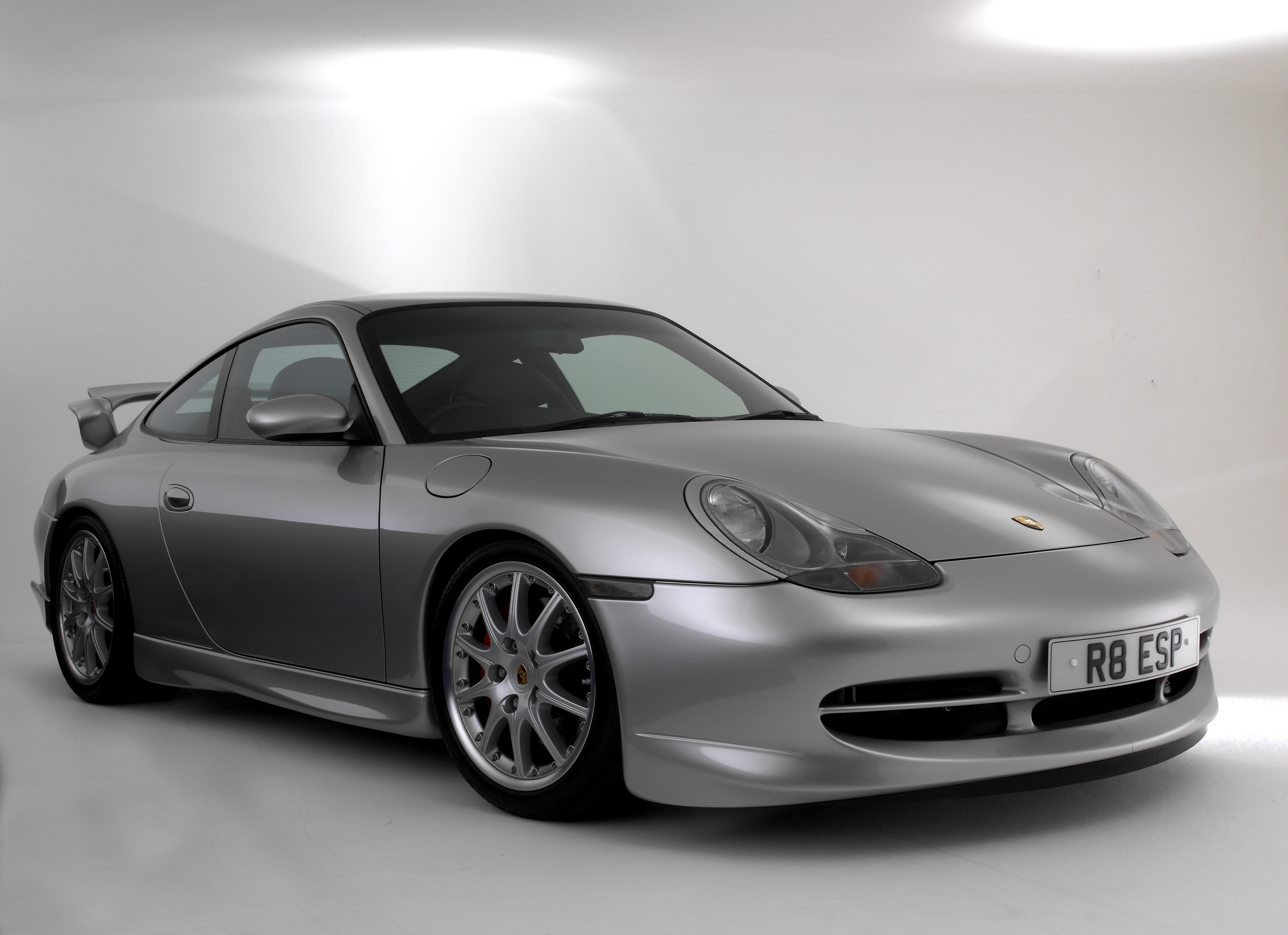 A silver 2000 996.1 Porsche 911 GT3 in a white studio