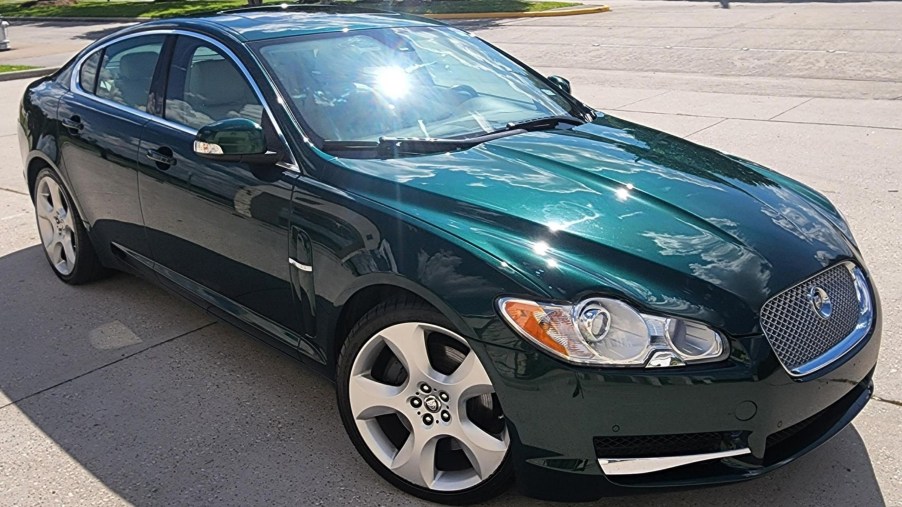 The front 3/4 view of a green 2009 Jaguar XF Supercharged in a driveway